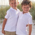 children standing in front of sand dune covered in sea oats at Crystal Beach, Destin Florida