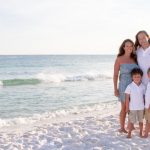 family standing in front of ocean on the emerald coast