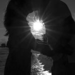 black and white photo of couple kissing in front of sunset on Destin Florida beaches