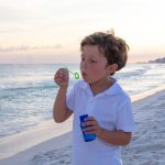 young boy on beach in Destin Florida, blowing bubbles