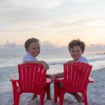 children sitting in red chairs on Crystal Beach in Destin Florida